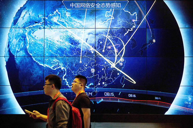 Attendees walk past an electronic display showing recent cyberattacks in China at the China Internet Security Conference in Beijing on Sept. 12, 2017.
Photo: AP
