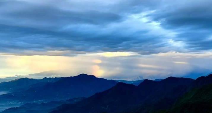南投縣集集大山出現雨瀑透著夕照的「霓虹光雨瀑」奇景，令人驚艷。（圖由民眾林建興提供）
