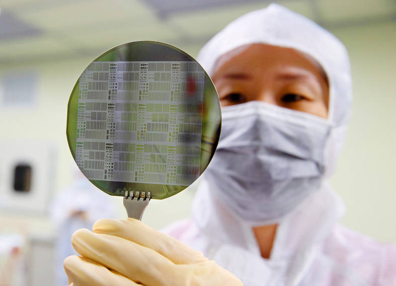 A researcher inspects a silicon wafer at a National Tsing Hua University lab in Hsinchu City on Sept. 11 last year.
Photo: CNA