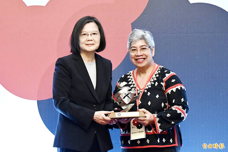 
President Tsai Ing-wen, left, awards Child Rights Coalition Asia regional executive director Amihan Abueva the Asia Democracy and Human Rights Award in Taipei yesterday.
Photo: George Tsorng, Taipei Times