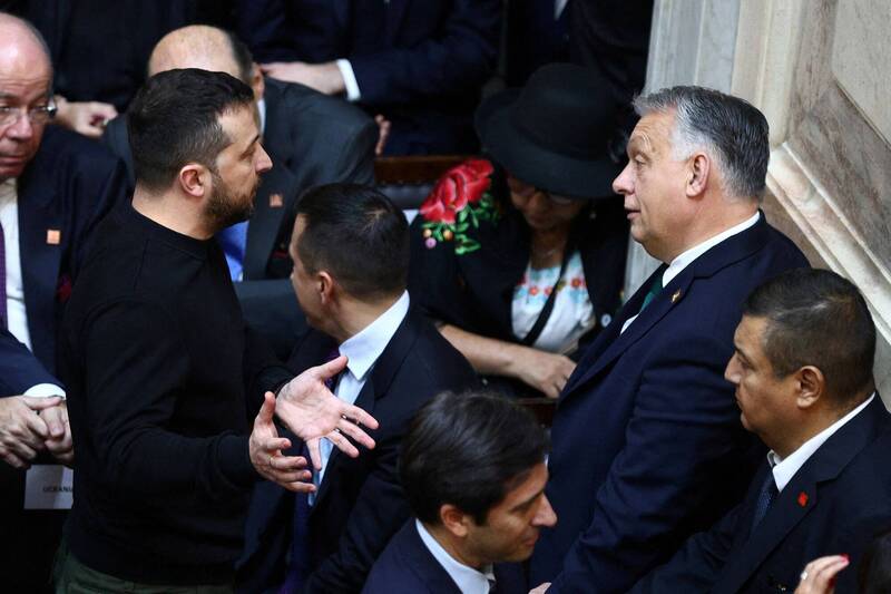 乌克兰总统泽伦斯基（左）10日在阿根廷总统就职典礼上与匈牙利总统奥班（右）激烈对话。（路透）(photo:LTN)