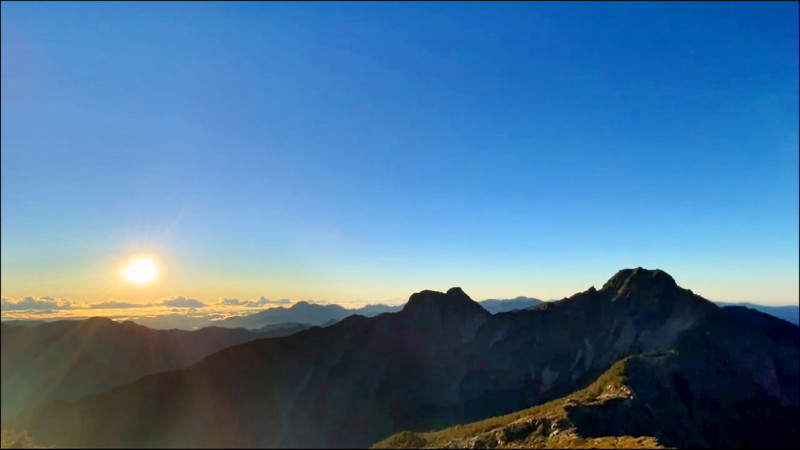 東北季風增強，但玉山天氣仍穩定，並記錄到玉山主峰（右側山峰）與雲海同框的壯闊日出。（玉山氣象站提供）