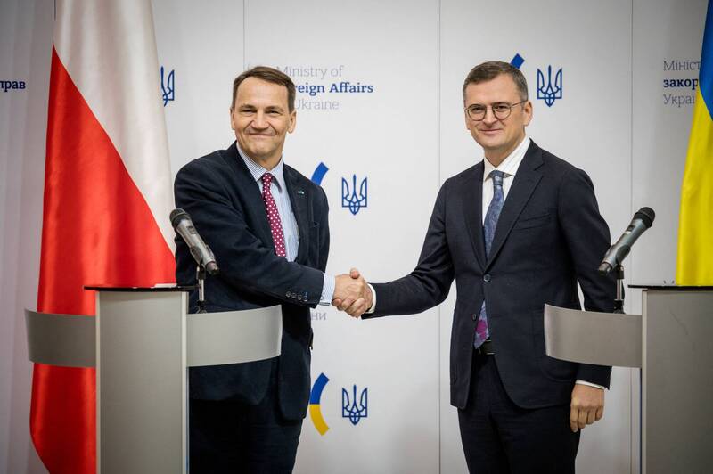 波兰外交部长西科尔斯基（左）与乌克兰外长库列巴（右）握手合影。（路透）(photo:LTN)
