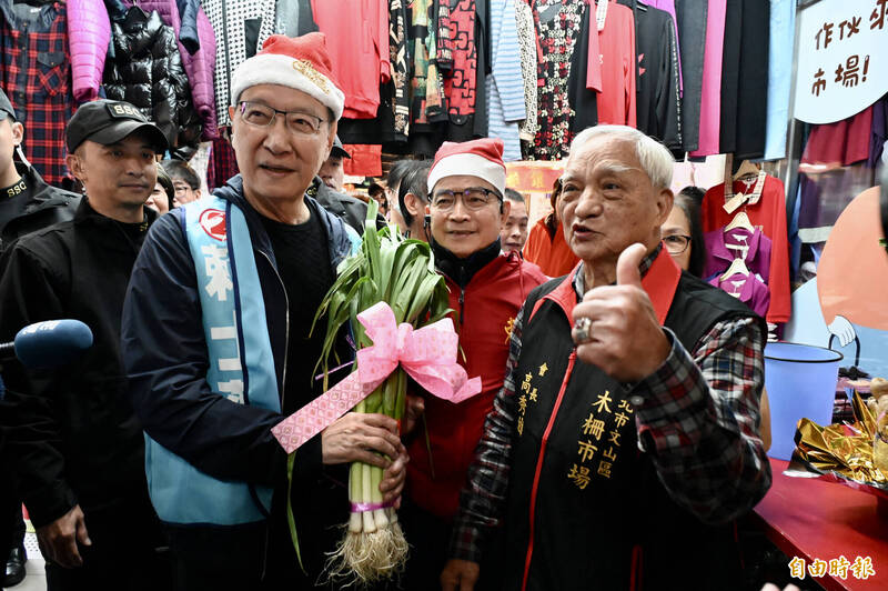 國民黨台北文山區立委候選人賴士葆（右二）今天上午與國民黨副總統候選人趙少康（左二）到木柵市場掃街拜票，適逢耶誕節前夕，特地戴上耶誕帽祝大家耶誕快樂。（記者叢昌瑾攝）