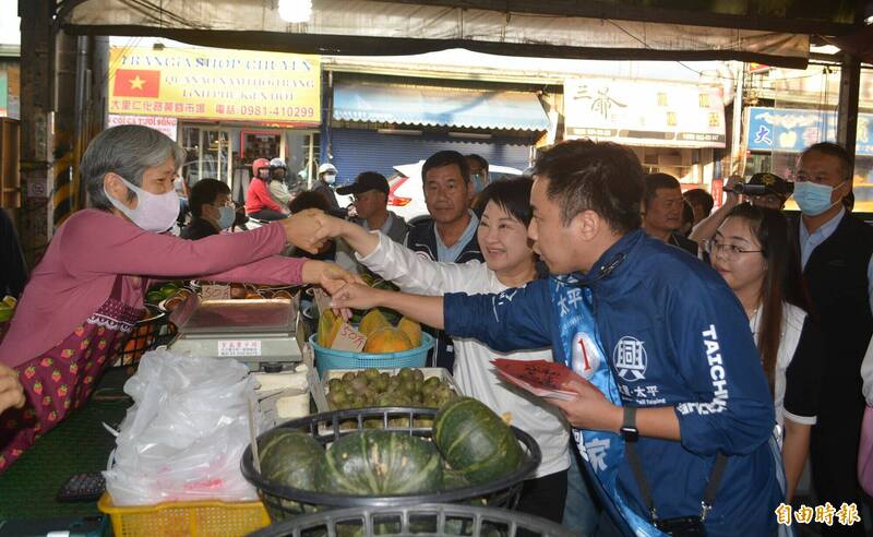 台中第7選區立委候選人林家興（前），今天在台中市長盧秀燕（後）陪同下，前往大里仁化黃昏市場拜票，親切跟攤商握手。（記者陳建志攝）