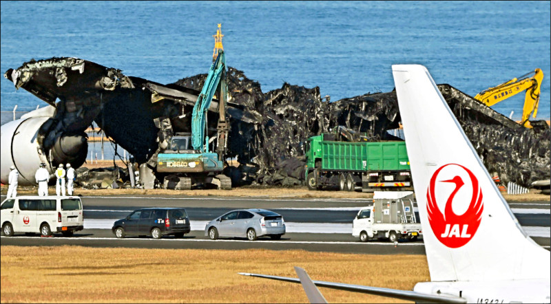 日本东京羽田机场的海上保安厅航机和日本航空客机相撞事故后，大型机具持续清理残骸。（美联社）(photo:LTN)