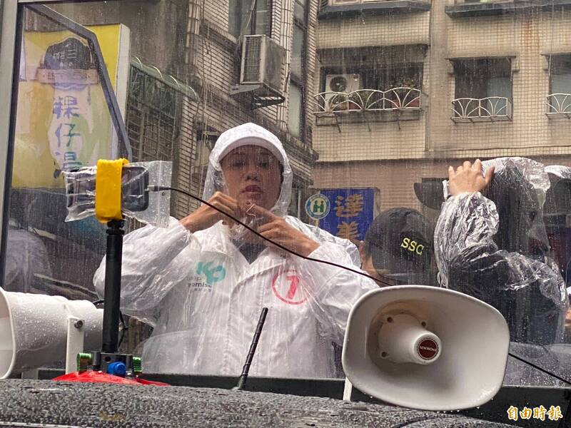 民眾黨副總統候選人吳欣盈今天到基隆車隊掃街，雖然天公不做美，吳欣盈仍然穿上小雨衣無懼風雨，逐一向民眾請託拜票
。（記者俞肇福攝）