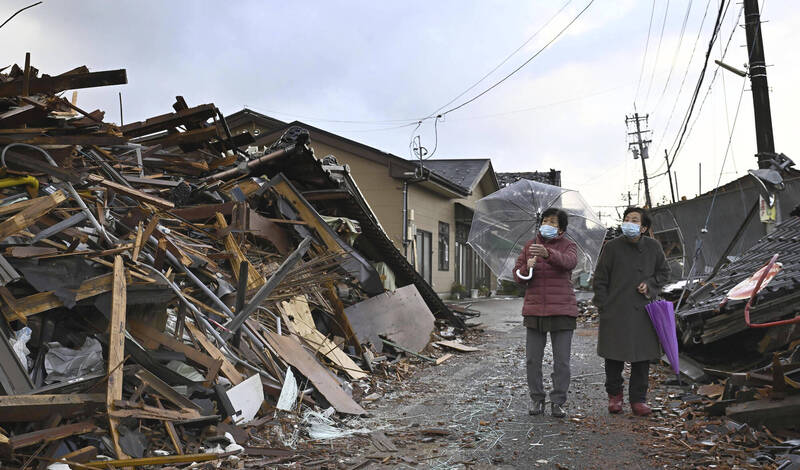 日本石川县元旦发生芮氏规模7.6强震，震后珠洲市居民走在倒塌房屋的废墟旁。（美联社）(photo:LTN)