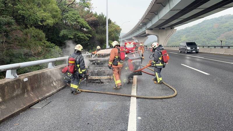 五楊高架上火燒車，消防人員於現場積極灌救。（記者徐聖倫翻攝）