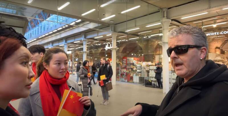 英國知名鋼琴家卡瓦納在倫敦商場直播彈鋼琴，卻遭遇一群自稱來自中國電視台、拿著五星旗的人找碴。。（圖翻攝自Brendan Kavanagh_YT）