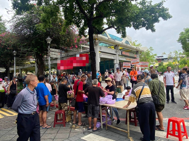 民間團體在艋舺公園發送愛心餐食。資料照。（社會局提供）