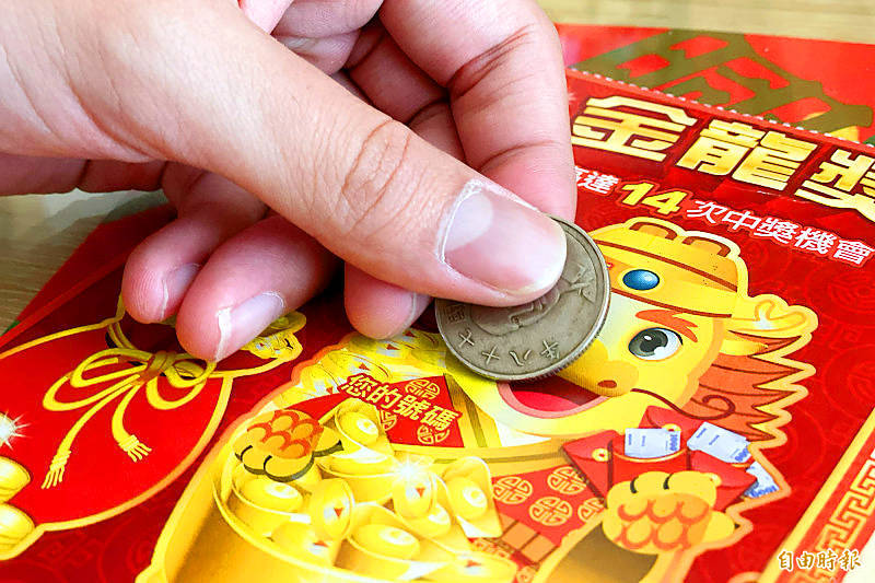 
A person scratches a lottery ticket at a vendor in Taipei on Sunday.
Photo: Chiu Chih-jou, Taipei Times