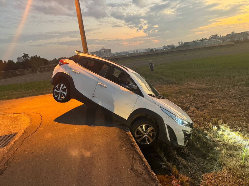 休旅車半車身卡在田裡動彈不得。（警方提供）