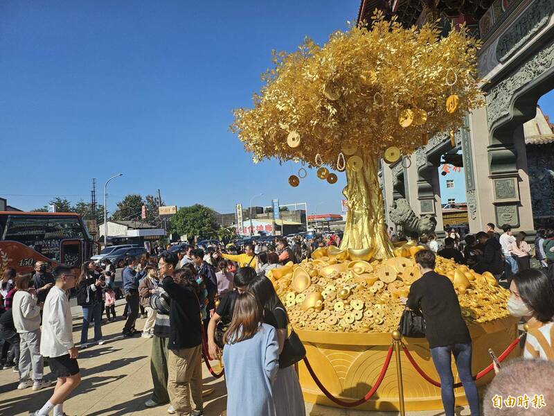 北港武德宮財神廟「財神寶樹」，民眾駐足樹下求財氣並拍照打卡。（記者鄭旭凱攝）