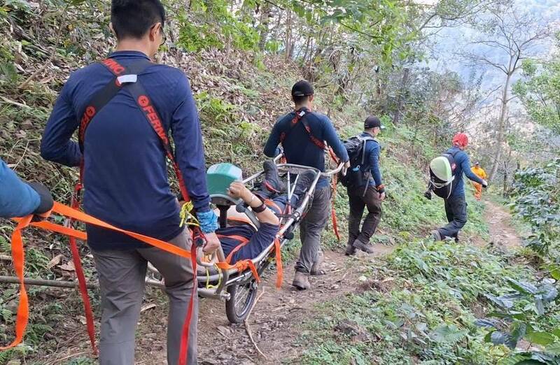 消防人員用擔架將陳男運送下山。（民眾提供）