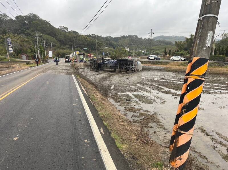 疑天雨路滑，曳引車失控滑行50公尺翻落田裡。（民眾提供）