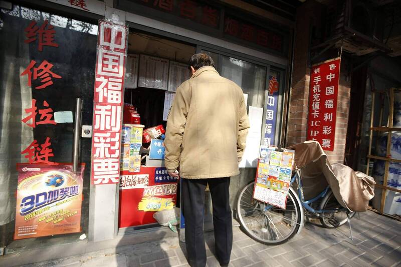 中国西安市推出结婚就送刮刮乐的催生活动。图为2013年12月29日在上海拍摄到1名男子站在中国福利彩票投注站外。（路透）(photo:LTN)