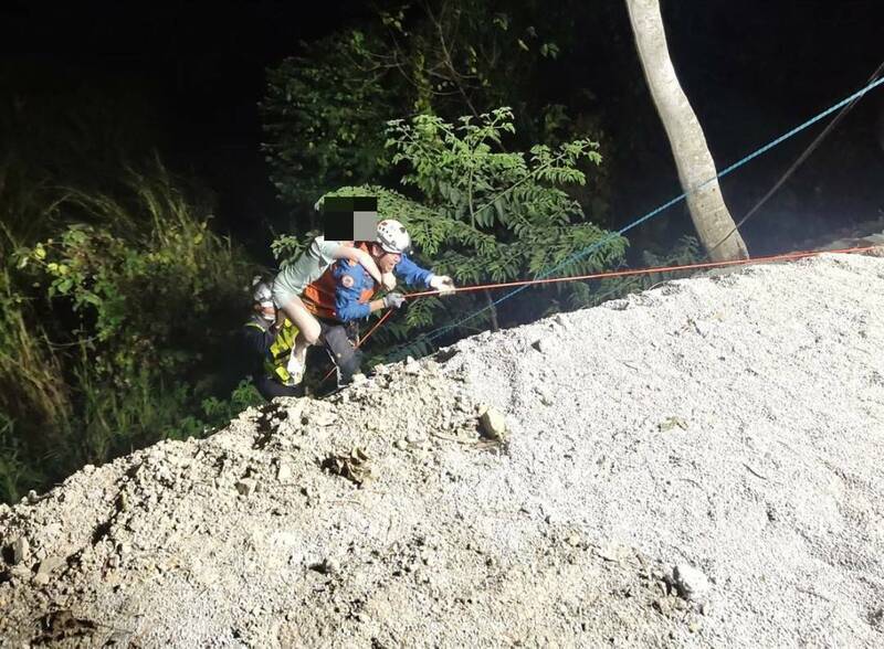 消防人員利用繩索垂降將謝女從車內救出，背負上道路，送醫救治。（民眾提供）