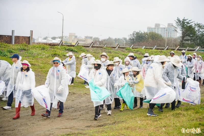 百餘名志工頂著10度低溫和寒風細雨到南寮淨灘。(記者洪美秀攝) 百餘名志工頂著10度低溫和寒風細雨到南寮淨灘。(記者洪美秀攝)