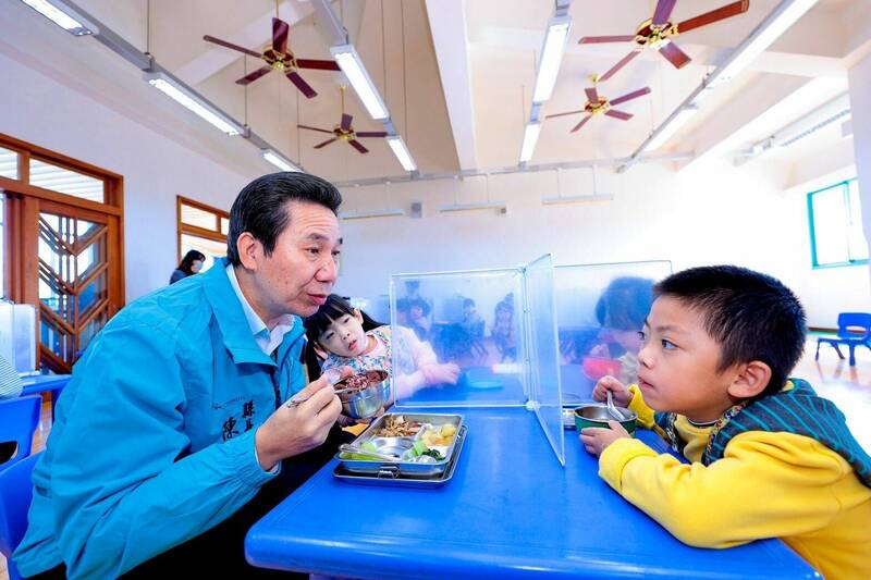 金門縣長陳福海（左）前往校園關心營養午餐製做烹調的過程並與學童共餐。（金門縣政府提供）