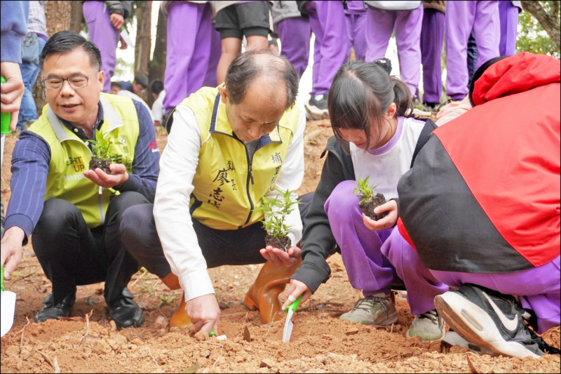 埔里鎮長廖志城（蹲者中）與溪南國小師生及多位民代一起在溪南國小種植320株的蜜源植物。（埔里鎮公所提供）