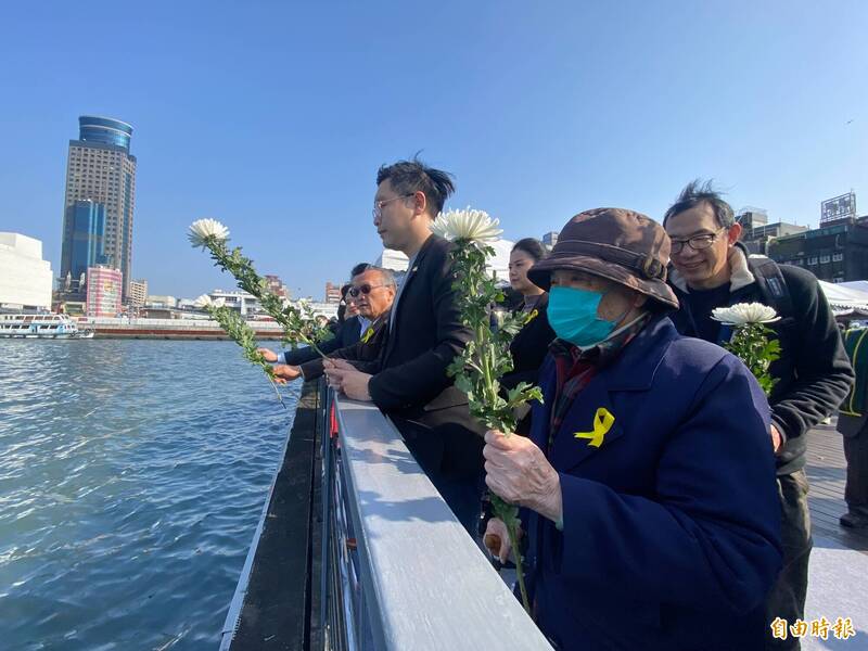 基隆市政府今天下午2點28分在海洋廣場舉辦228事件追思活動，受難者家屬手持菊花拋向基隆港，表達對受難者的追思。（記者俞肇福攝）