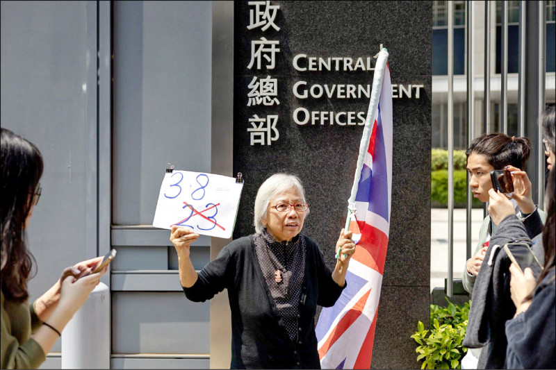 人称王婆婆的王凤瑶八日在香港特区政府总部外孤身一人举起英国国旗及写有「反对廿三条」的标语，抗议政府强行为基本法第廿三条立法。（彭博）(photo:LTN)