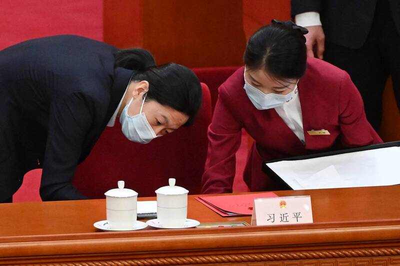 11日中国全国人民代表大会闭幕式前，工作人员正在准备习近平的办公桌。（法新社）(photo:LTN)