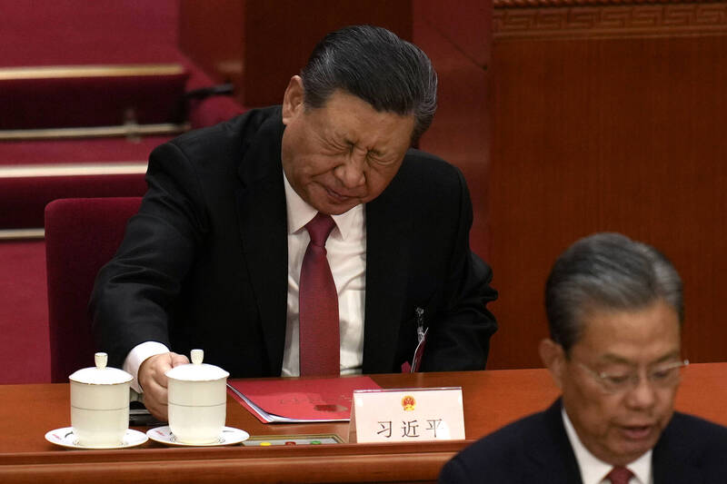 11日在北京人民大会堂举行的中国全国人民代表大会闭幕式上，中国国家主席习近平（后排）喝了一杯茶后面露痛苦表情。（美联社）(photo:LTN)