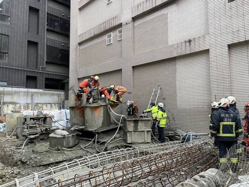 新北市新店區中央四街一處建築工地工人不慎跌落水泥攪拌機，大批消防人員趕抵搶救。（記者陸運鋒翻攝）