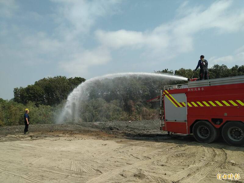 高市消防局今天上午繼續在華崗路廢棄物掩埋場火警現場灑水降溫。（記者蘇福男攝）