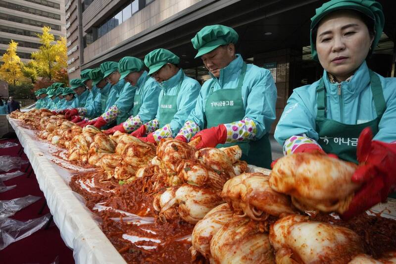 南韩农水产食品流通公社20日发布的报告显示，以2022年为准，该国每10户家庭中就有4户的子女不吃泡菜。图为南韩「韩亚金融集团」高层在总部前制作传统韩国泡菜，发送给弱势族群。（美联社资料照）(photo:LTN)