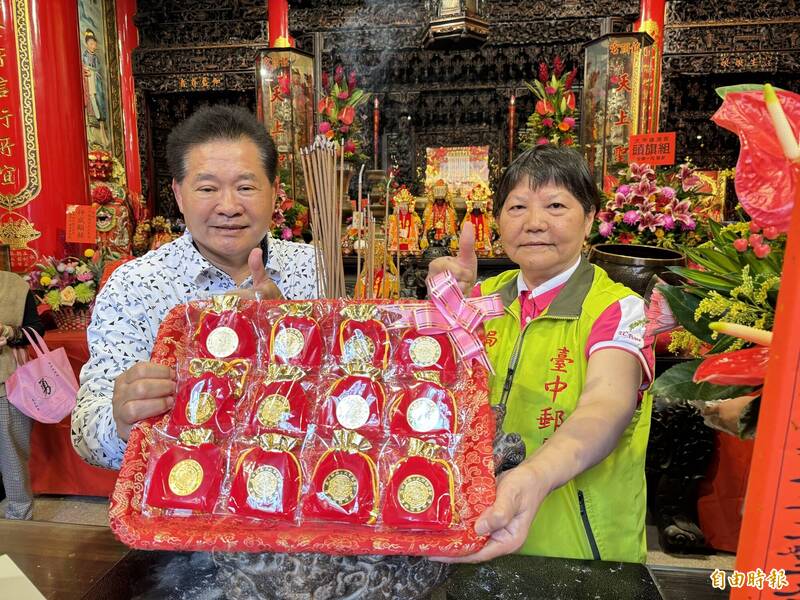 台中郵局局長陳湘慈（右）與鎮瀾宮副董事長鄭銘坤（左），共同為惜福郵摺及錢母祈福過火。 （記者歐素美攝）