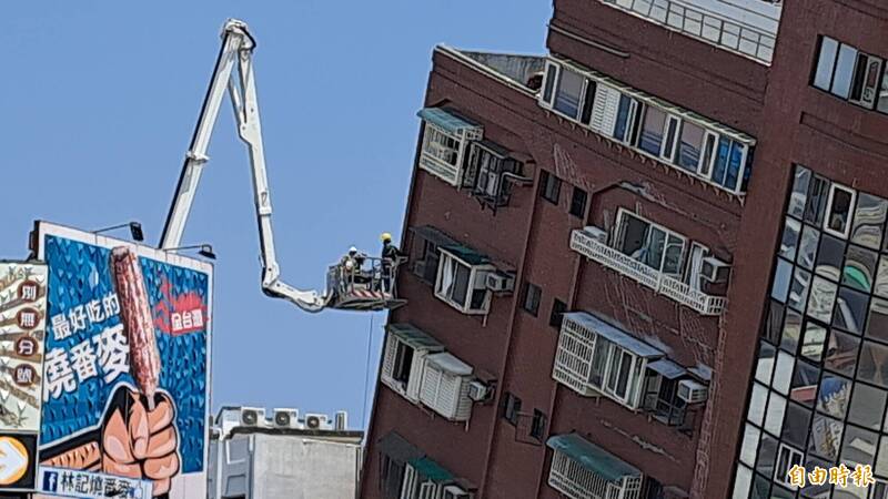 土木技師乘高空吊臂，從外進行天王星大樓鑽心取樣。（記者黃明堂攝）