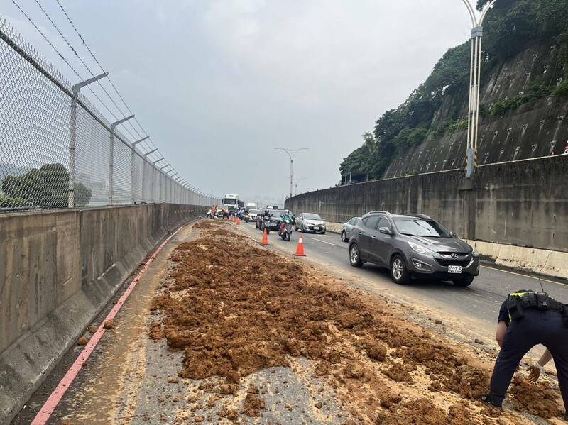 關渡大橋淡水端引道今天上午發生一輛砂石車土石滲漏，造成一名女騎士摔車受傷。（記者吳仁捷翻攝）