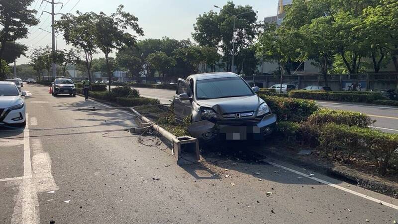 轎車衝上德民路安全島，將路燈電桿直接撞斷。（讀者提供）