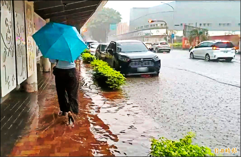 金門昨天中午雷雨交加，人行道也被雨水淹沒，行人腳上的鞋都成了「雨鞋」。（記者吳正庭攝）