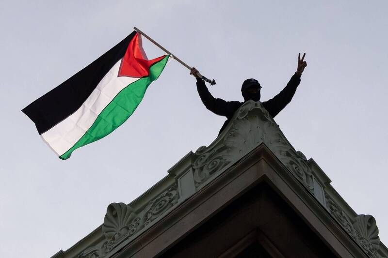 佔领「汉密尔顿厅」的示威者在屋顶挥舞巴勒斯坦旗帜。（彭博）(photo:LTN)
