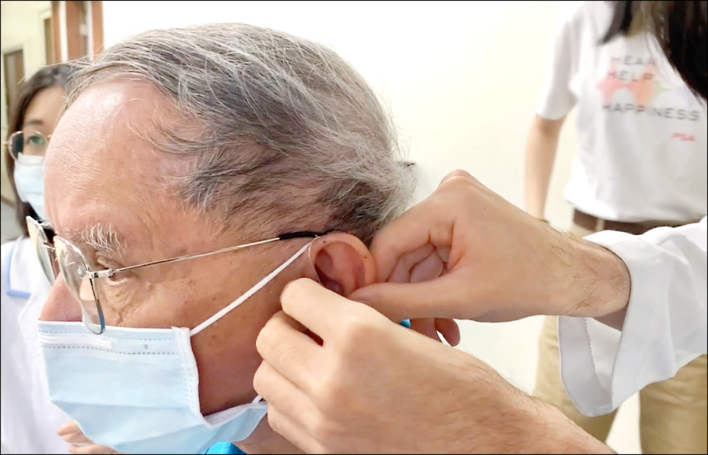 去年我國聽覺機能障礙者首度突破十三萬人，醫師建議及時配戴助聽器，可維持聽力，有助延緩失智。圖為聽力師協助聽障者配戴助聽器及提供專業諮詢。
（PSA華科慈善基金會提供）