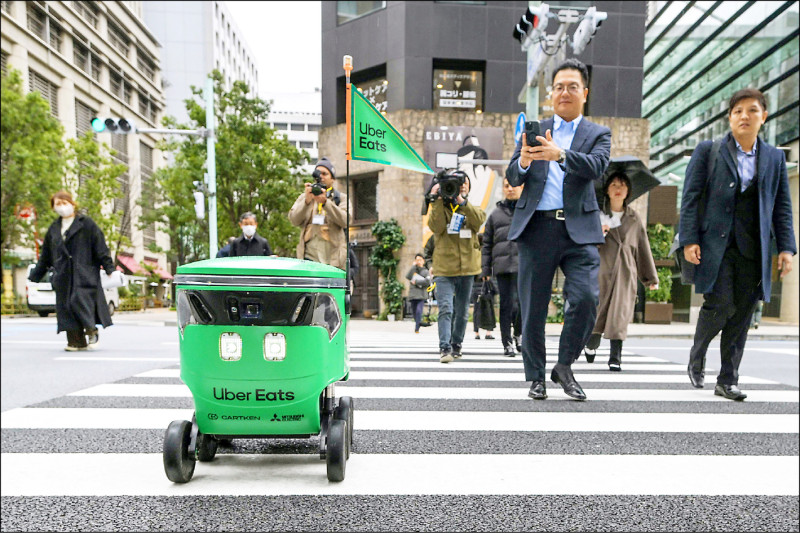1具日本Uber Eats送餐机器人在东京市中心送餐时，走斑马线过马路。（法新社）(photo:LTN)