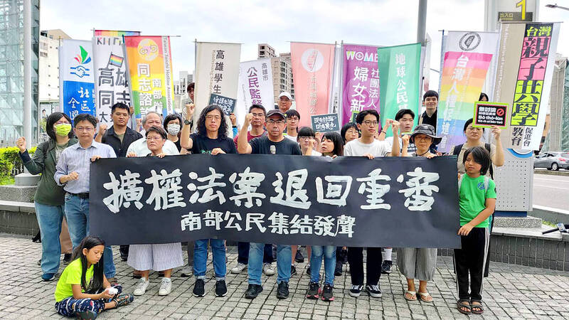 Representatives from a coalition of civic groups in Kaohsiung yesterday hold a banner calling for legislative reform bills to be sent back to committee for deliberation.
Photo: CNA