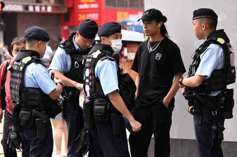 香港警察在銅鑼灣街上盤查一名男子，懷疑他試圖紀念六四事件35週年。（法新社）