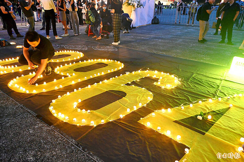 A man places a candle at Liberty Square in Taipei last night to mark the 35th anniversary of the 1989 Tiananmen Square Massacre in Beijing.
Photo: Wang Yi-sung, Taipei Times A man places a candle at Liberty Square in Taipei last night to mark the 35th anniversary of the 1989 Tiananmen Square Massacre in Beijing.
Photo: Wang Yi-sung, Taipei Times