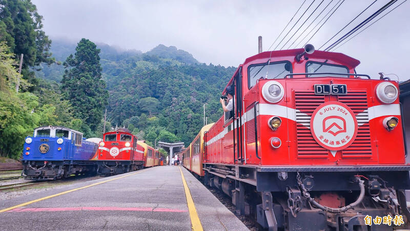 阿里山林鐵3輛列車在奮起湖站同框，上行列車掛上全線通車紀念牌，畫面空前絕後。（記者林宜樟攝）