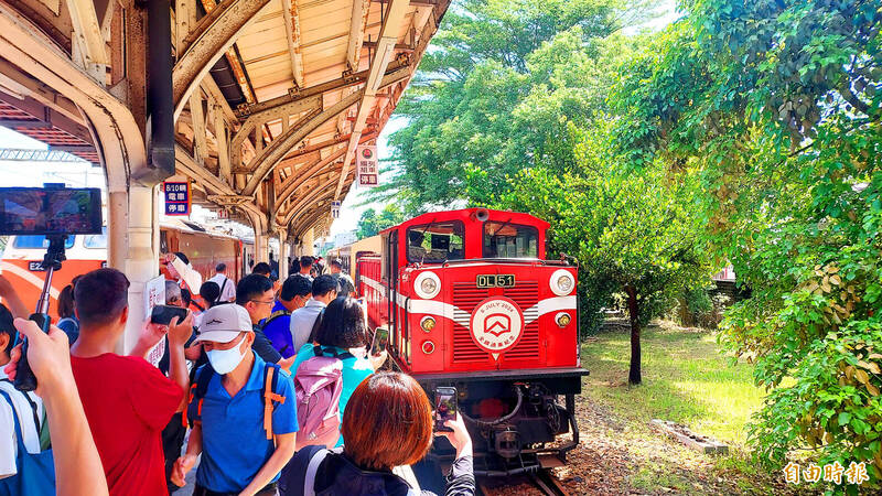 
People photograph a train departing from the Alishan Forest Railway’s Chiayi Station yesterday. The railway resumed full operations yesterday, 15 years after typhoons damaged the line’s infrastructure.
Photo: Lin Yi-chang, Taipei Times