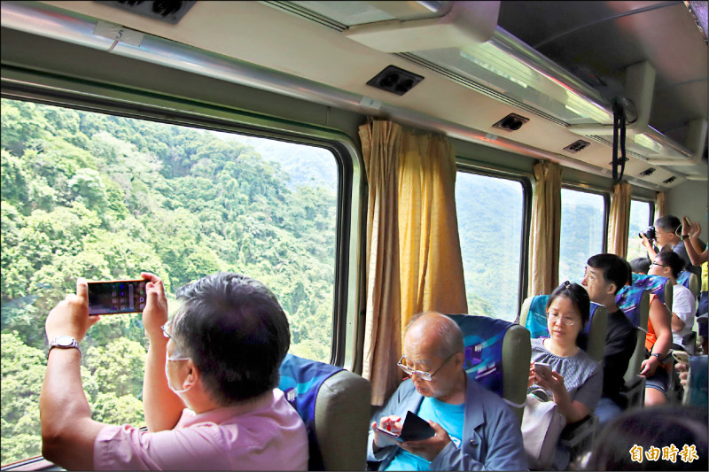 乘客整趟旅程盡覽林相變化，在林鐵車廂拍攝風景。（記者林宜樟攝）