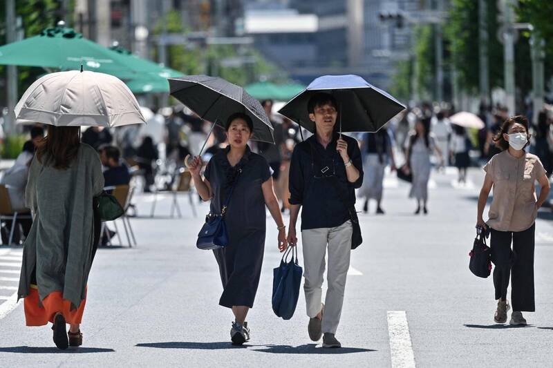 東京進入炎夏，銀座的逛街人潮紛紛撐傘遮陽。（法新社）