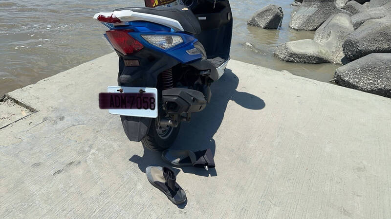 騎士將藍色機車(見圖)停放堤防,隨即落水失蹤。(讀者提供) 騎士將藍色機車(見圖)停放堤防,隨即落水失蹤。(讀者提供)