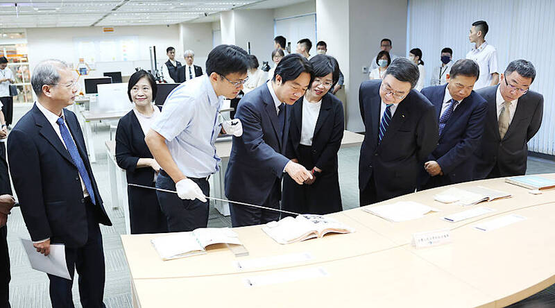 President William Lai, center, examines a document at the National Archives Administration in Taipei yesterday morning.
Photo: CNA
President William Lai, center, examines a document at the National Archives Administration in Taipei yesterday morning.
Photo: CNA