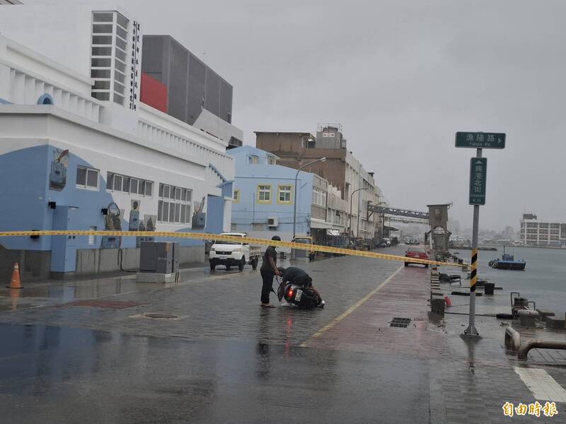 馬公興港北街因海水倒灌拉起封鎖線，仍有人不信邪硬闖，出現人仰車翻景象。（記者劉禹慶攝）